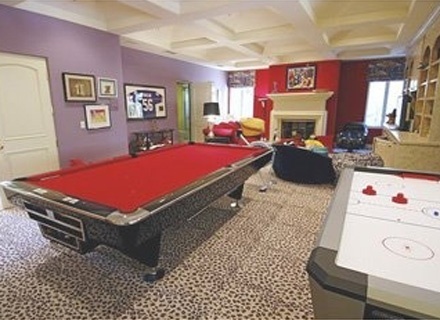 Paris Hilton tem uma enorme mesa de sinuca na sala com lareira, que tem carpete de oncinha, na casa de Beverly Hills