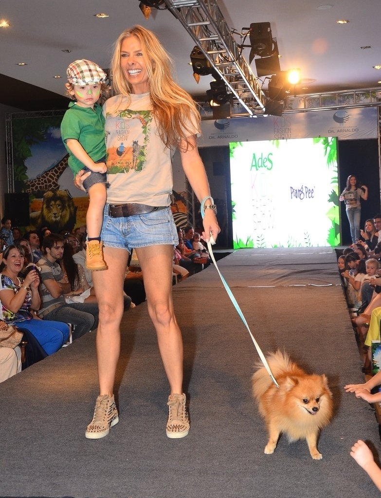 20.out.2013 - Segurando um cachorro, Adriane Galisteu desfila com o filho Vittorio no Kids Fashion Show, evento de moda realizado em São Paulo
