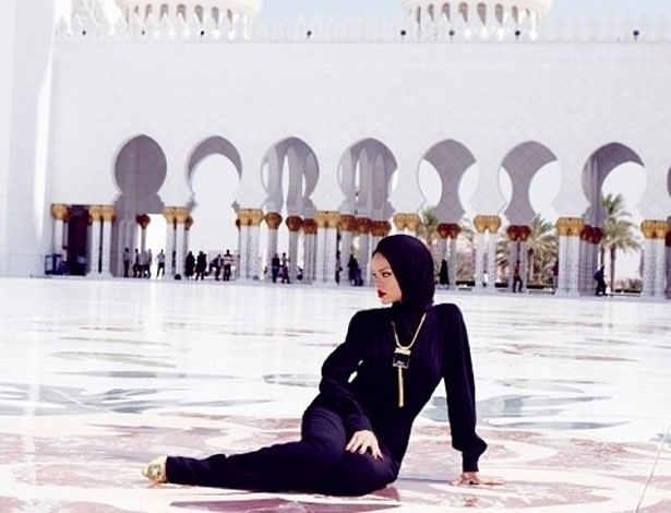 19.out.2013 - Rihanna posa em mesquita de Abu Dhabi, capital dos Emirados Árabes, usando um macacão preto de mangas longas e um lenço cobrindo seus cabelos e seu pescoço.