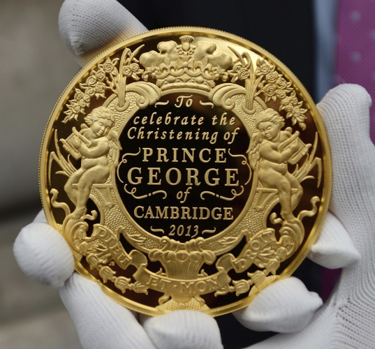 23.out.2013 - Chefe da casa da moeda britânica, Gordon Summer, mostra uma moeda de ouro fabricada em comemoração ao batizado do príncipe George, na capela real do palácio de St.James, em Londres