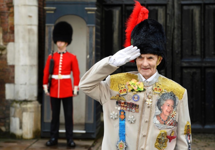23.out.2013 - Fã da realeza posam para fotos em frente à capela real do Palácio de St.James, em Londres