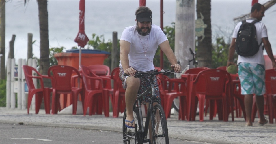 28.out.2013 - Barbudo, Murilo Benício anda de bicicleta na praia da Barra, na zona oeste do Rio