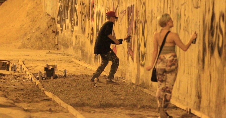 5.nov.2013 - Justin Bieber grafita muro do bairro de São Conrado, no Rio de Janeiro, durante a madrugada. O cantor e sua equipe foram para o local por volta das 3h. De acordo com a agência de fotografias AgNews, os fotógrafos presentes no local foram agredidos pelos seguranças de Bieber e a polícia chegou a ser chamada. O astro teen ficou grafitando por cerca de três horas e atendeu a fãs