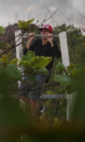 5.nov.2013 - Justin Bieber faz exercícios em uma barra que fica na praia da Barra da Tijuca. O cantor estava acompanhado de amigos e seguranças e tentou passar despercebido, usando óculos e boné