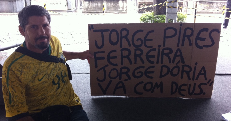 7.nov.2013 - Edson Rosa, fã de Jorge Dória, leva cartaz no velório do ator no Memorial do Carmo, no Rio