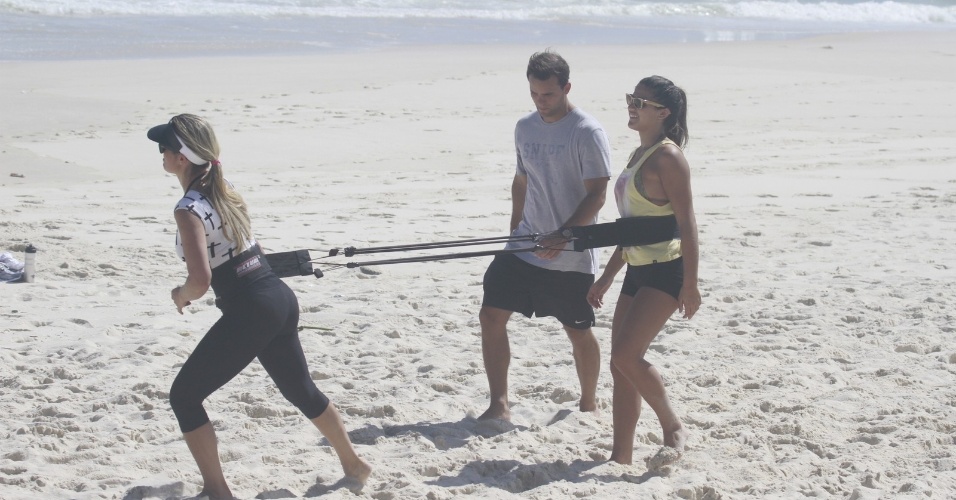 8.nov.2013 - Flávia Alessandra aproveitou a tarde desta sexta para se exercitar na praia da Barra, no Rio. A atriz estava acompanhada das filhas; a adolescente Giulia, e a caçula Olívia