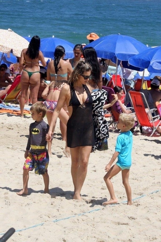 Fernanda Lima não se importou com a praia lotada e se divertiu com os filhos João e Francisco no Rio