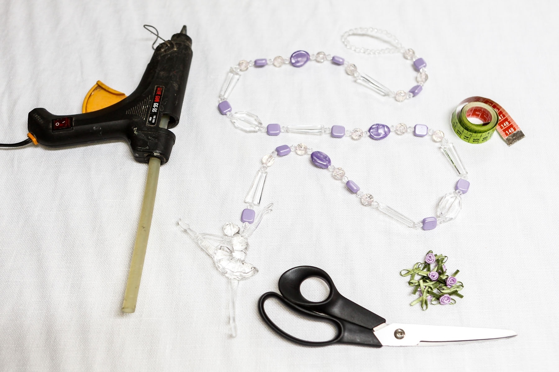 Confira os materiais necessários para personalizar a cortina: pistola de cola quente, puxador de cortina, fita métrica, apliques de flor e tesoura - Leandro Moraes/UOL