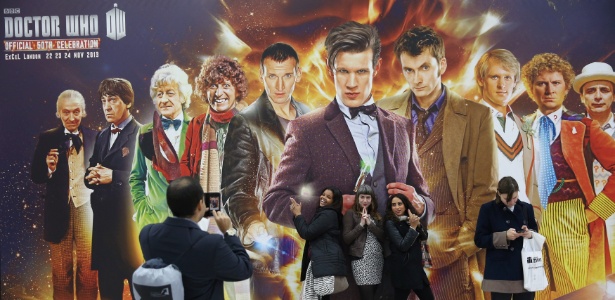 Fãs posam em frente a poster comemorativo dos 50 anos da série "Doctor Who" em evento em Londres