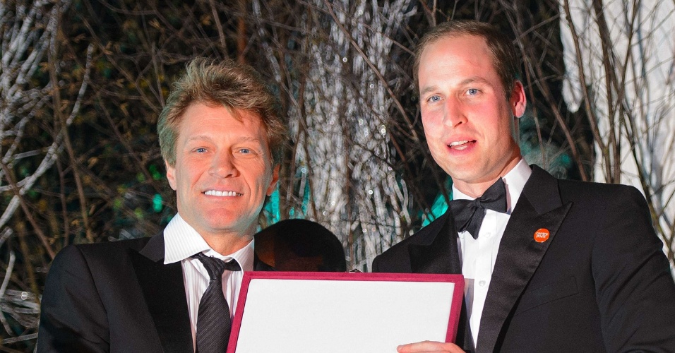 26.nov.2013 - Príncipe William entrega ao cantor Jon Bon Jovi o prêmio Great Britain Youth Inspiration Award durante evento de caridade. O Duque de Cambridge cantou com o artista e com Taylor Swift durante o jantar de gala
