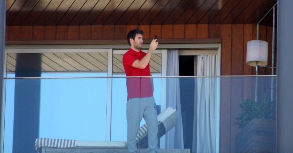 28.nov.2013 - Usando uma camisa do Brasil, o ator Joshua Bowman, da serie "Revenge", fotografa a paisagem do Rio de Janeiro da varanda de seu quarto em um hotel em Ipanema