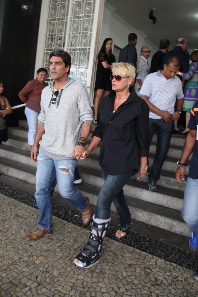 30.nov.2013 - Com bota ortopédica e acompanhada do namorado Juno, Xuxa deixa o velório do produtor musical João Araújo, pai de Cazuza - Photo Rio News