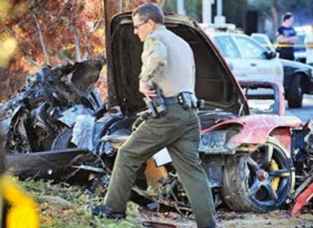 30.nov.2013 - Policiais trabalham perto dos destroços do Porsche vermelho que bateu neste sábado (30) em poste de luz, em Valencia, um condado de Los Angeles, nos Estados Unidos. O acidente matou Paul Walker , 40, ator da franquia "Velozes e Furiosos", e um amigo dele, confirmou um empresário de Walker - Divulgação