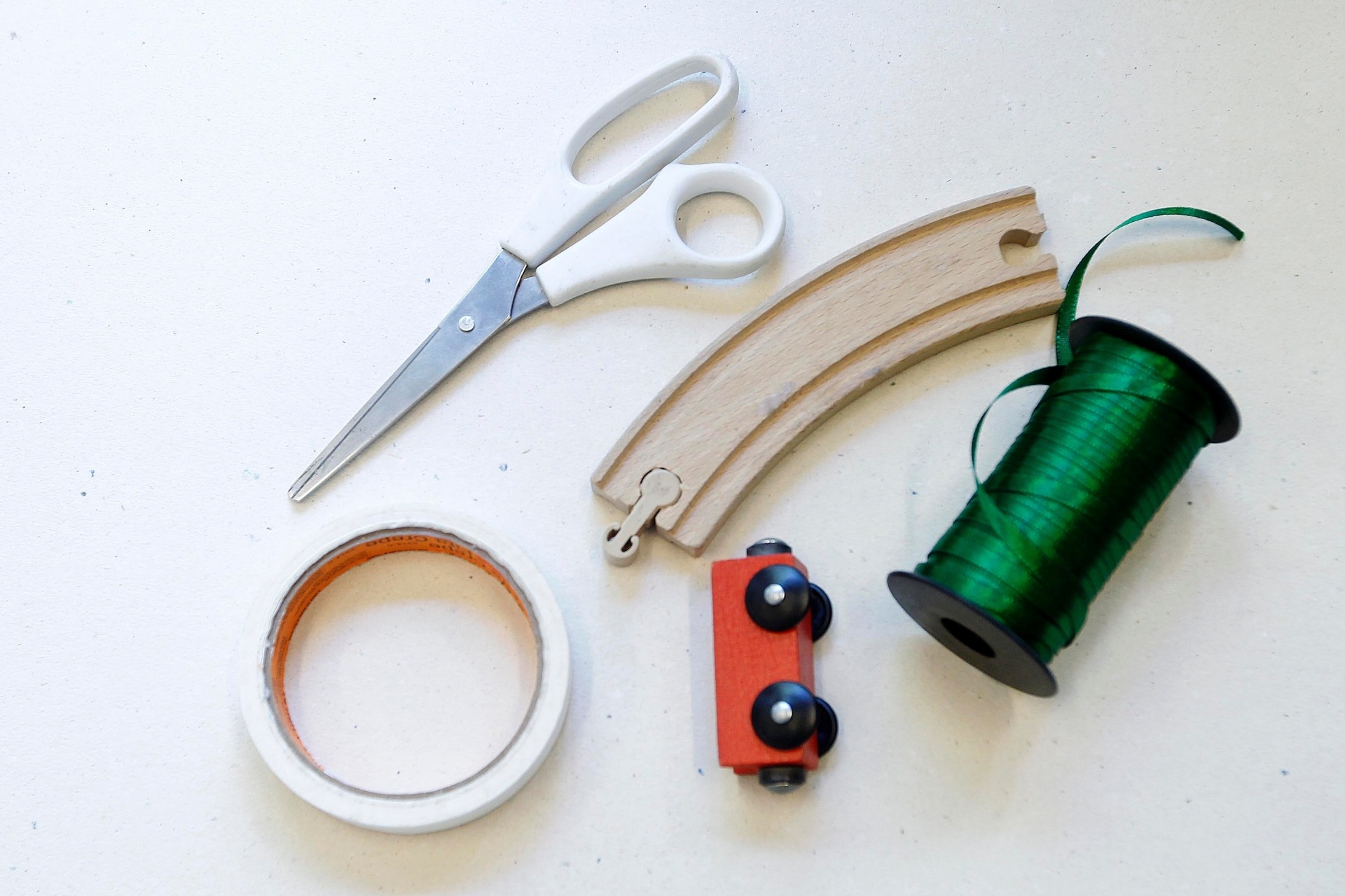 Brinquedos que precisam ser montados também podem fazer parte da decoração da árvore de Natal. Nesse caso, Janaina escolheu um trem e seu trilho. Para isso usou tresoura, fita de cetim e fita crepe - Reinaldo Canato/UOL