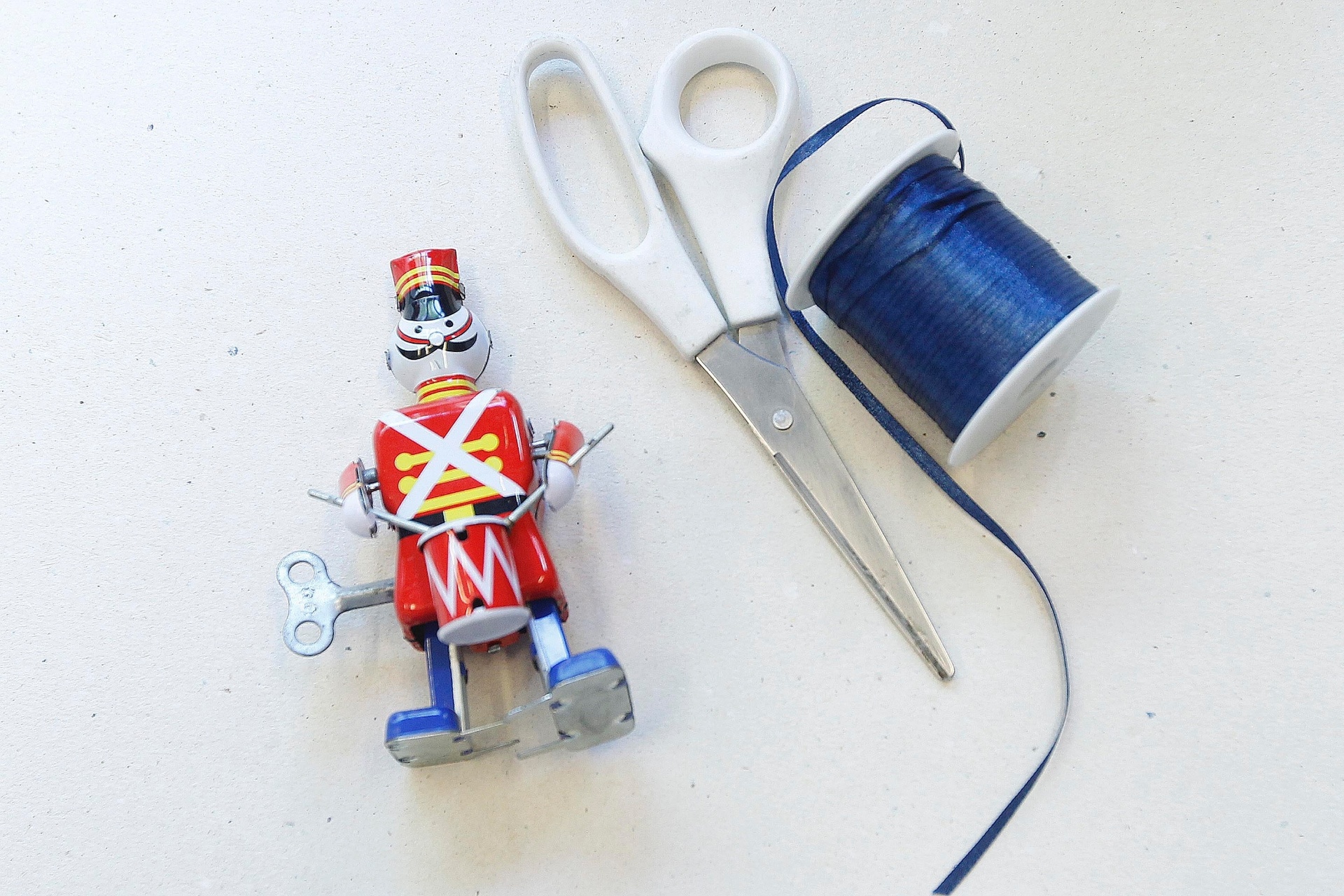 No caso dos brinquedos que não têm uma passagem para fita, escolha uma das extremidades para amarrá-la. Utilize tesoura, fita de cetim e, claro, um brinquedo, que nesse caso, é um soldadinho de corda - Reinaldo Canato/UOL