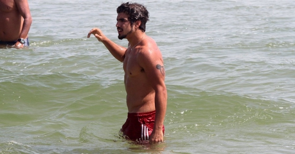 05.dez.2013- Caio Castro se refresca no mar e exibe corpo em forma