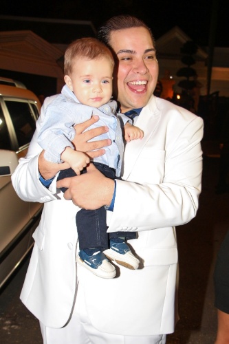 6.dez.2013 - De branco, Tiago Abravanel posa com o sobrinho no casamento de Silvia Abravanel