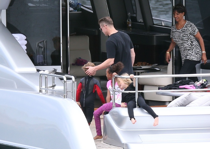 3.dez.2013 - Brad Pitt parabeniza o filho Knox após o menino fazer tand up paddle em Sydney, na Australia. Também na foto, Zahara e Vivienne