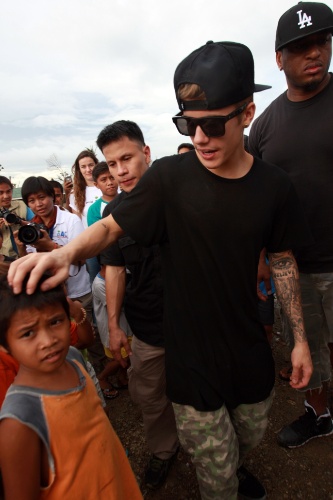 10.dez.2013 - O cantor Justin Bieber visita uma escola com sobreviventes do tufão Haiyan, que atingiu as Filipinas em novembro