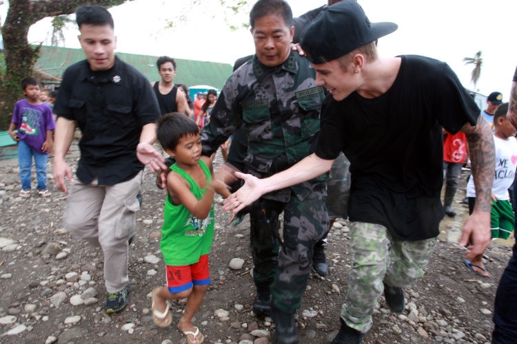 10.dez.2013 - O cantor Justin Bieber visita uma escola com sobreviventes do tufão Haiyan, que atingiu as Filipinas em novembro