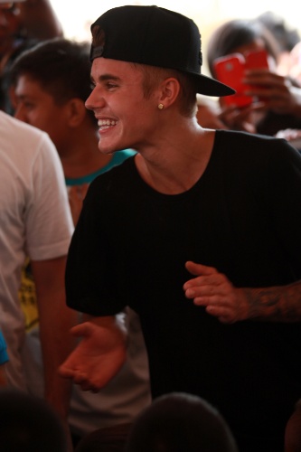 10.dez.2013 - O cantor Justin Bieber visita uma escola nas Filipinas e canta a música "Noite Feliz" com alunos sobreviventes do tufão Haiyan, que atingiu o país em novembro