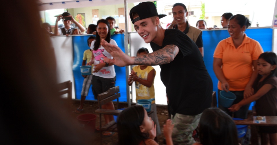 10.dez.2013 - O cantor Justin Bieber visita uma escola nas Filipinas e canta a música "Noite Feliz" com alunos sobreviventes do tufão Haiyan, que atingiu o país em novembro