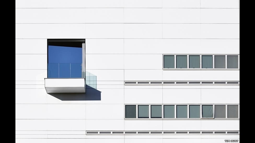 As linhas simples e os tons claros de um muro de um colégio na região de West Midlands, na Inglaterra, são interrompidos pelo reflexo do céu azul, na foto de Tim Hunt - Tim Hunt