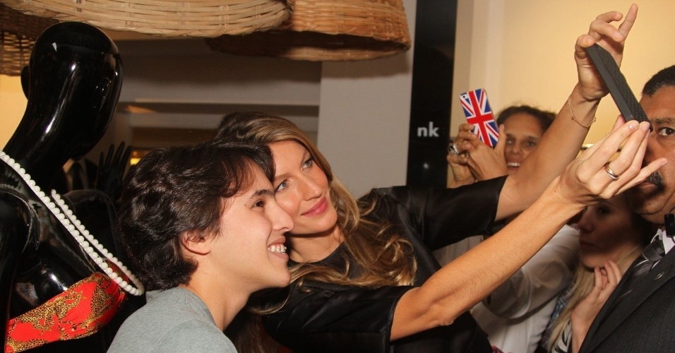 11.dez.2013 - Gisele Bündchen mostrou ser simpática ao posar para foto ao lado de um fã. A modelo participou do lançamento da coleção de lingerie que leva seu nome