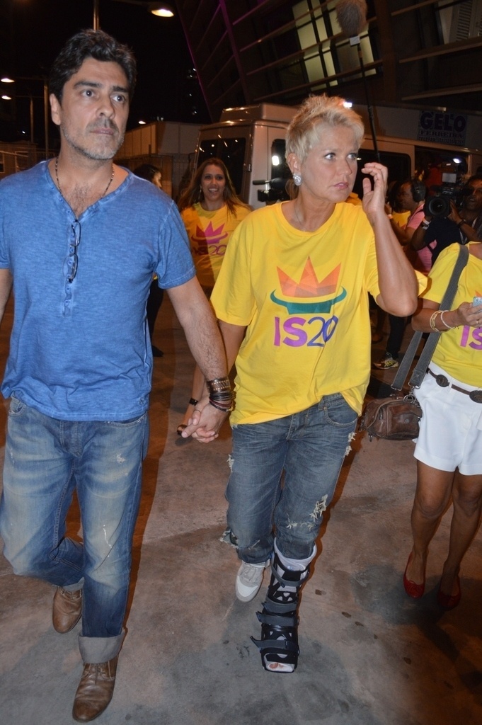 14.dez.2013 -  Xuxa e o namorado, Junno Andrade, chegam à gravação do DVD em comemoração aos 20 anos de carreira de Ivete Sangalo na Arena Fonte Nova, em Salvador. A apresentadora  está usando uma bota ortopédica há quase um mês, quando sofreu uma queda durante a gravação de seu programa - Felipe Souto Maior/AgNews