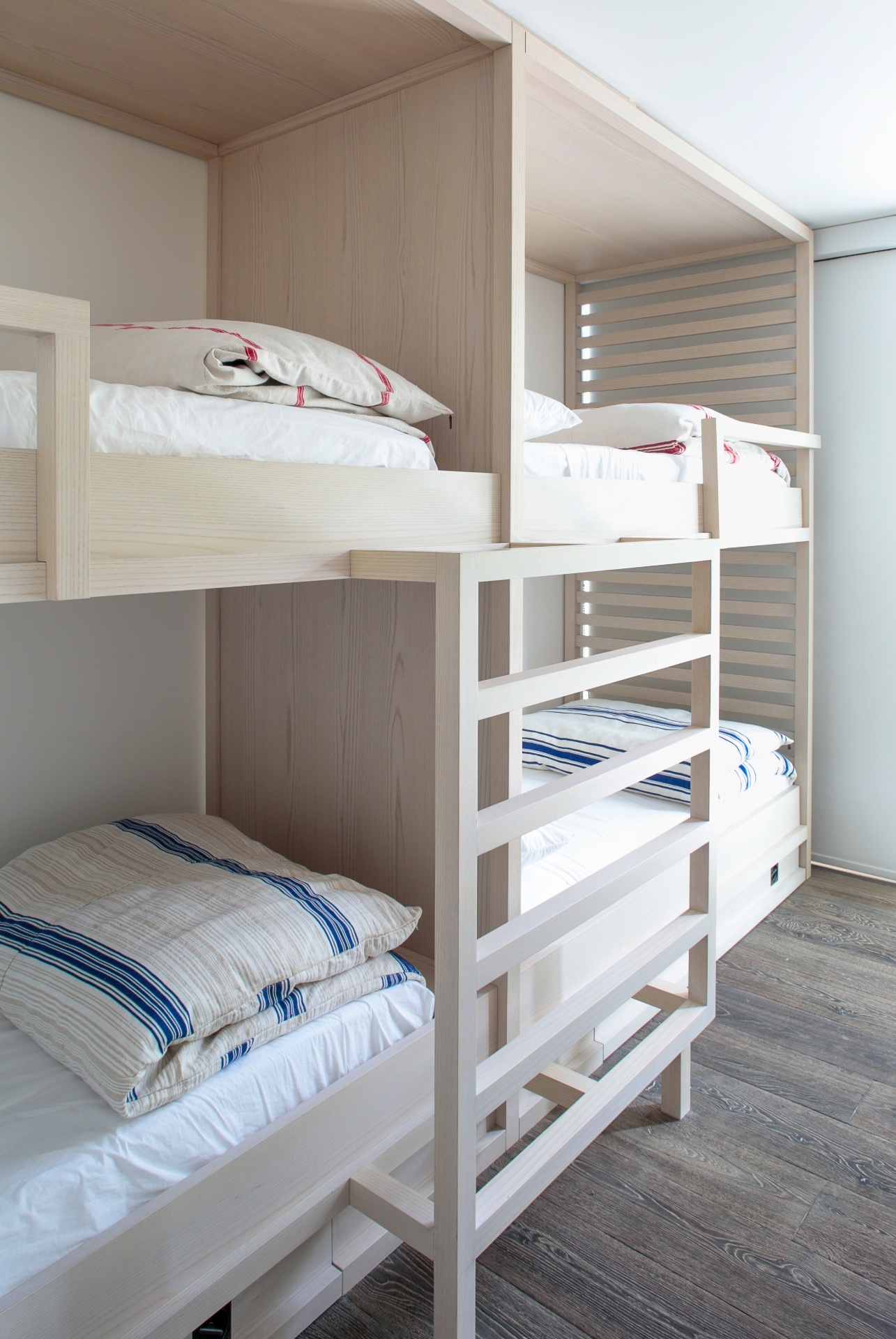 (Imagem do NYT, usar apenas no respectivo material) Beliches modulares e edredons listrados dispostos na ala de hóspedes promovem uma sensação de "acampamento de verão". Como George Yabu afirma: "Estar no acampamento evoca bons tempos" - Eric Striffler/ The New York Times