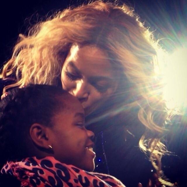 19.dez.2013 - A cantora Beyoncé beija a filha adotiva de Madonna Mercy James em show em Nova York