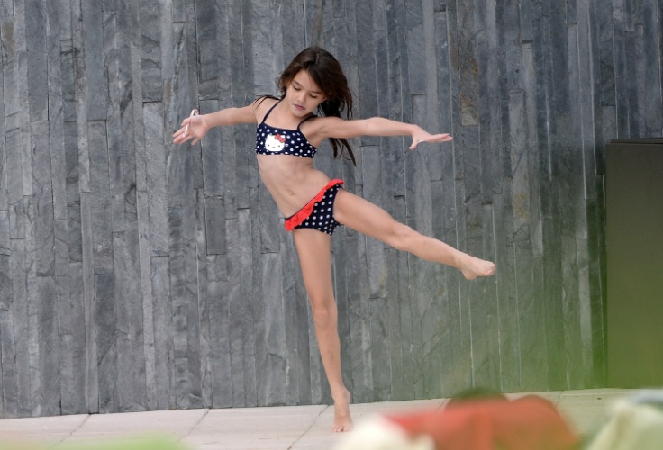 30.dez.2013 - Aos 7 anos, Suri Cruise faz passos de balé enquanto brinca em piscina em Miami, onde passou o penúltimo dia do ano com a mãe a uma amiguinha