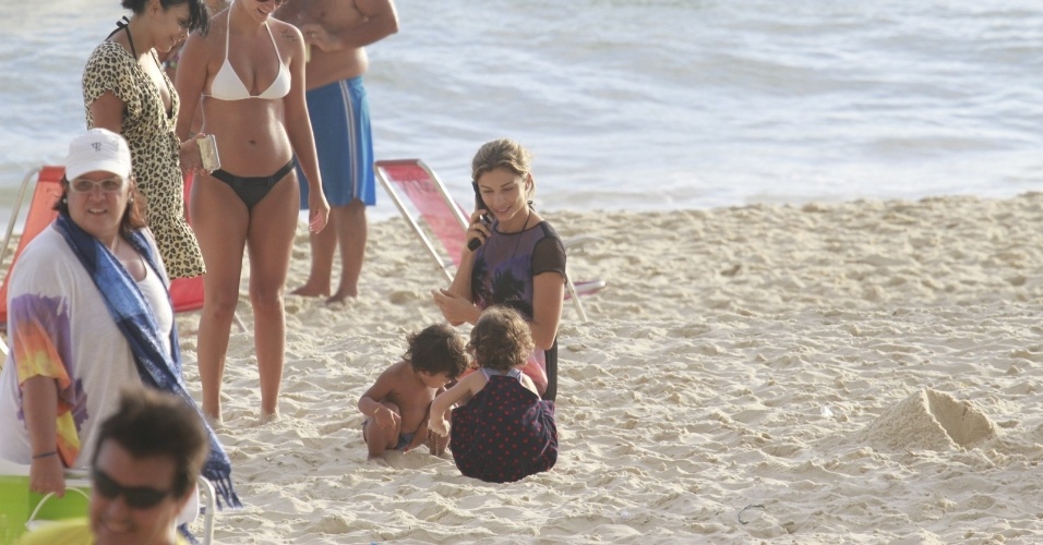 9.jan.2014 - Após o passeio de bicicleta, Grazi e Sofia se divertiram nas areias da praia da Barra da Tijuca, na zona oeste do Rio