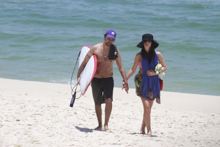 10.jan.2014 - Grávida, Alinne Moraes esconde a barriga em dia de praia