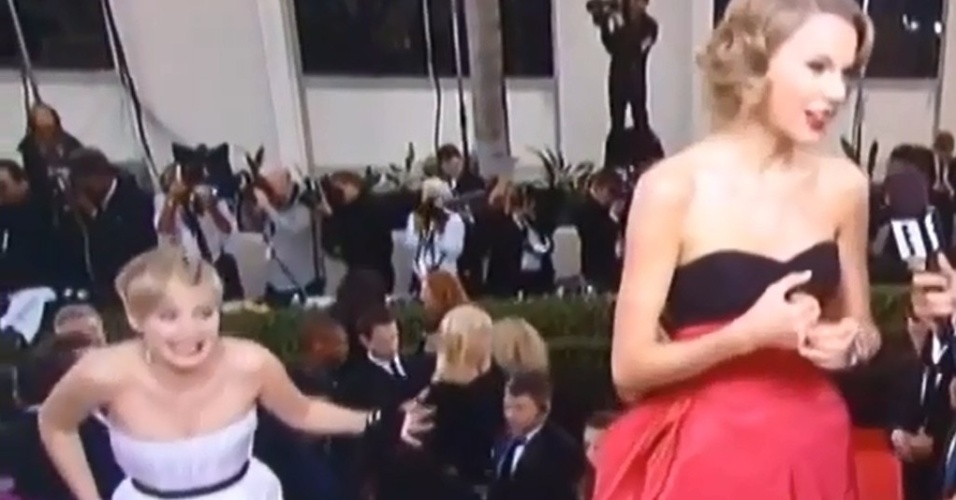 12.jan.2014 - Jennifer Lawrence faz careta durante entrevista de Taylor Swift no tapete vermelho do Globo de Ouro 2014