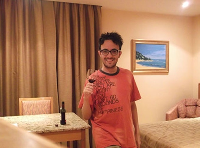 No quarto de hotel, Alisson brinda com uma taça de vinho