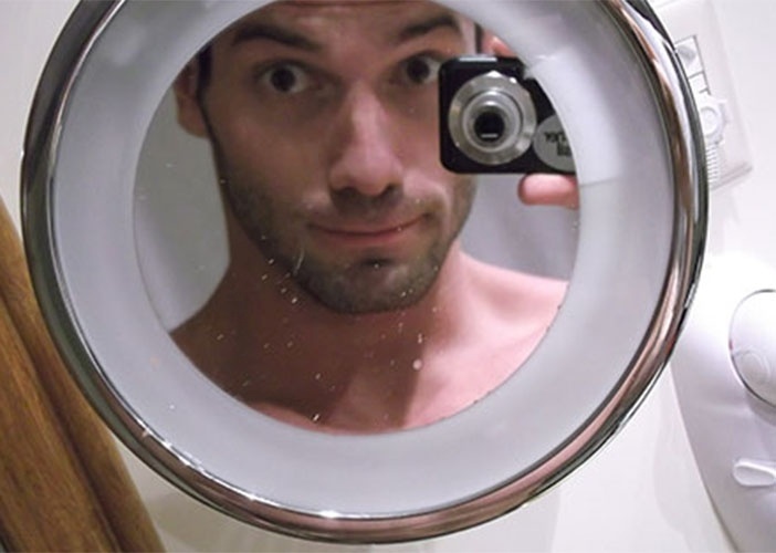 Roni faz graça no espelho do banheiro do hotel onde está confinado