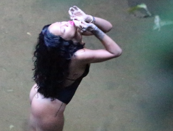 15.jan.2014 - Rihanna fotografa de maiô fio-dental e decote em uma cachoeira, no Rio de Janeiro. A cantora está no país para estrelar editorial da revista "Vogue Brasil"