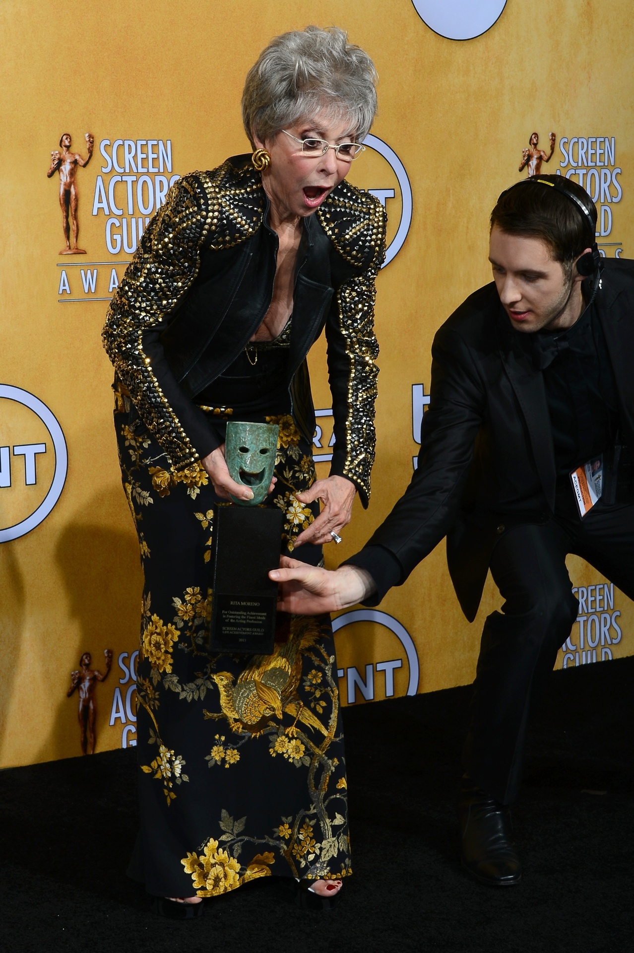 18.jan.2014 - Rita Moreno brinca com prêmio e quase deixa cair troféu especial pelo conjunto da obra - Ethan Miller/AFP