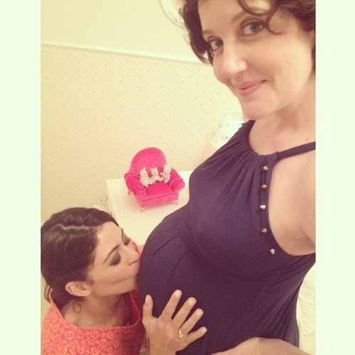 21.jan.2013 -  Grávida, Larissa Maciel recebeu beijo na barriga da amiga, a atriz Carol Castro. Larissa está grávida de oito meses de Milena