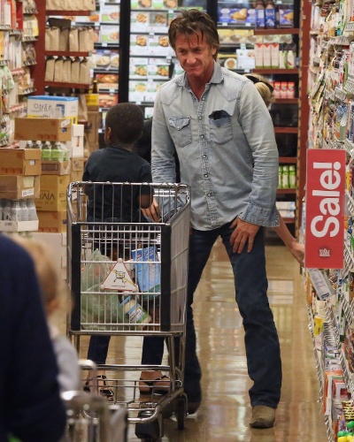 22.jan.2014 - Sean Penn e Charlize Theron são fotografados fazendo compras juntos em um mercado em West Hollywood. O ator divertiu o filho da atriz, Jackson, fazendo caretas para o menino durante as compras