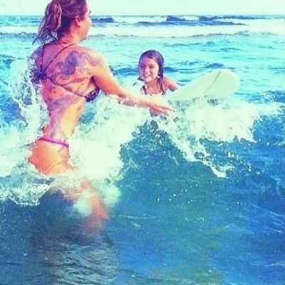 24.jan.2014 - Luize Altenhofen ensina a filha, Greta, a surfar na praia de Ubatuba, no litoral de São Paulo