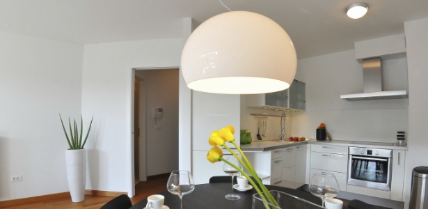 Para uma sala de jantar integrada à cozinha, o ideal é optar por luminárias de mesma linguagem visual - Getty Images