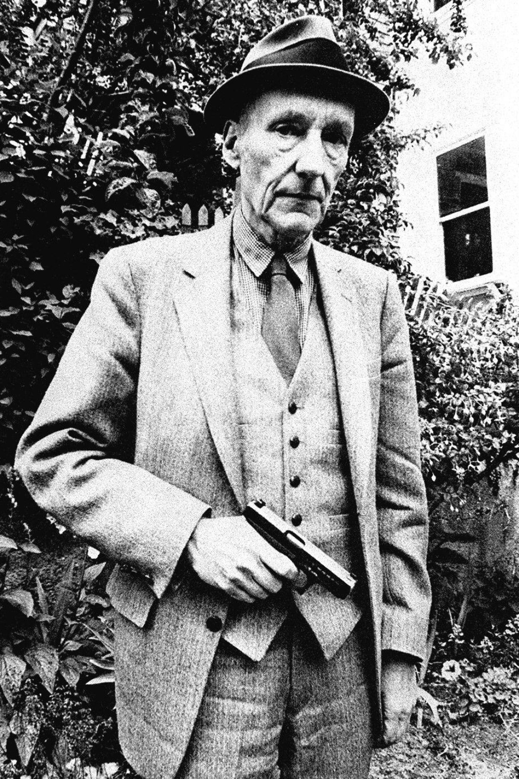 William Burroughs posa para foto segurando uma arma no jardim de uma casa em San Francisco - Reprodução