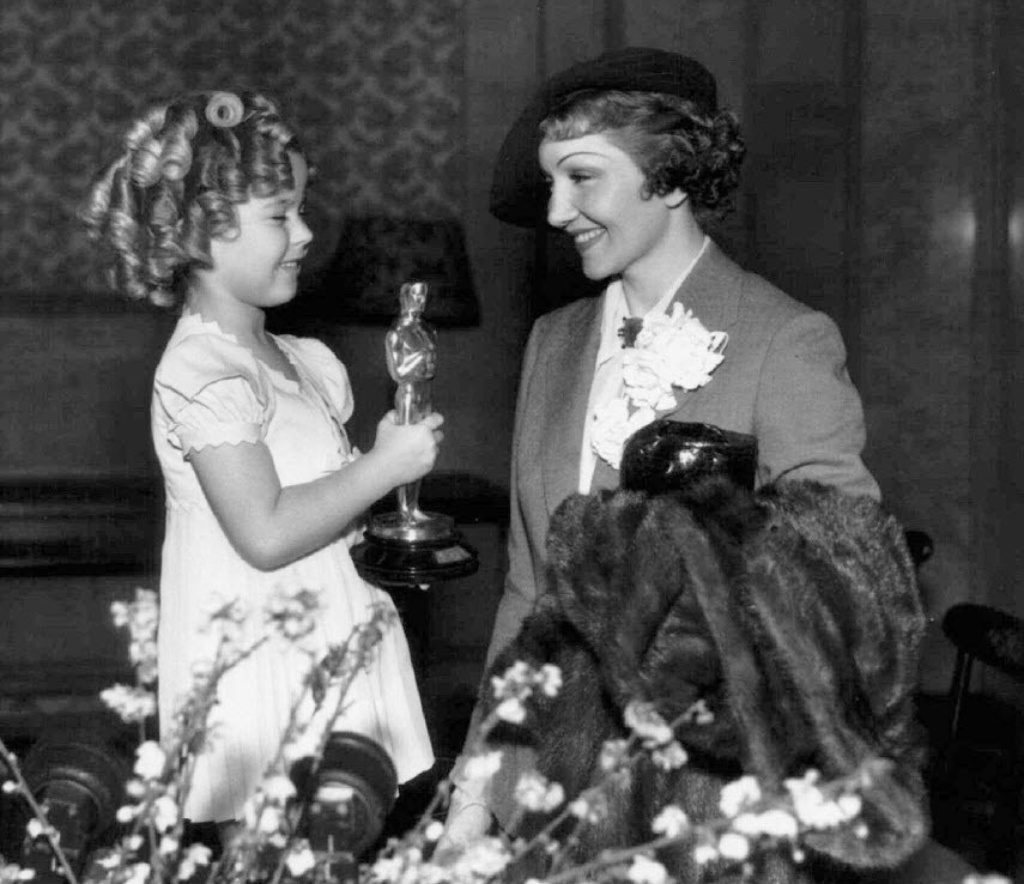 A pequena Shirley Temple segura o Oscar da atriz Claudette Colbert, em 1935 - Reuters