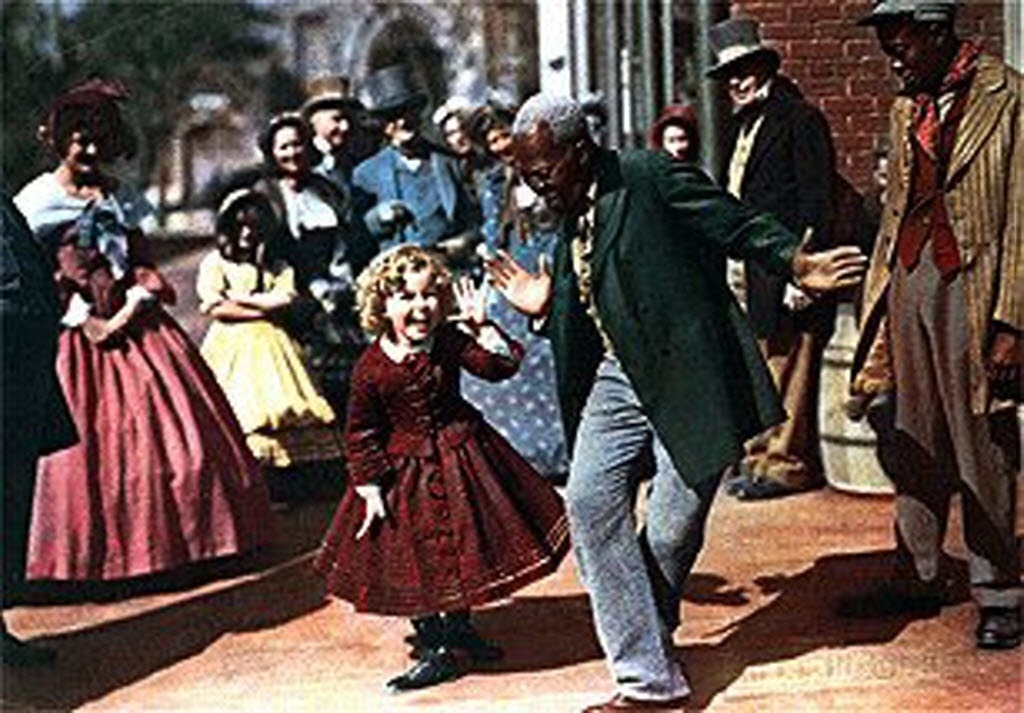 Shirley dança com o ator Bill Robinson em cena colorida do filme "A Mascote do Regimento" (1935) - Divulgação