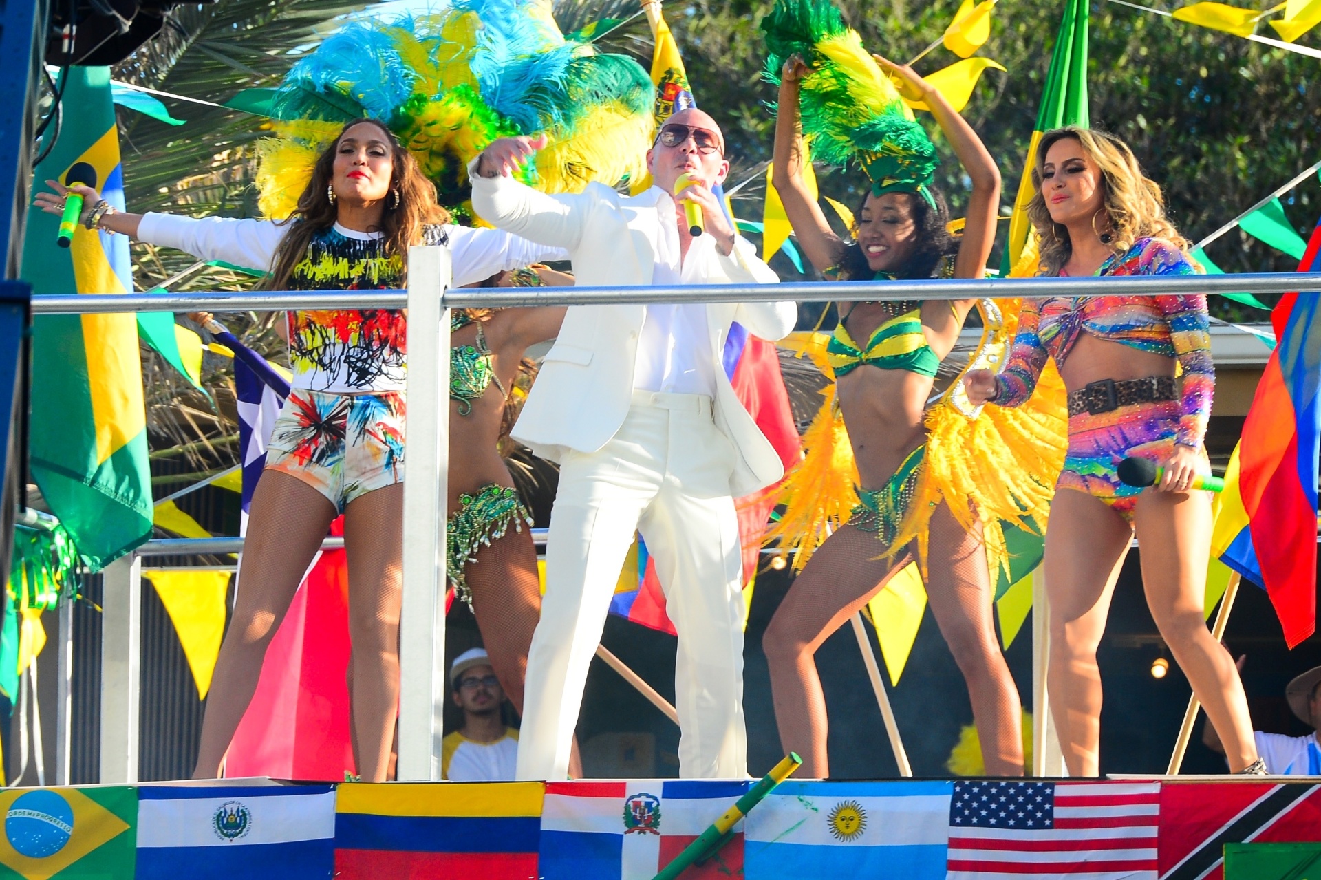 12.fev.2014 - As cantoras Jennifer Lopez e Claudia Leitte e o rapper Pitbull gravaram em Miami o clipe da música "We Are One",  tema da Copa do Mundo 2014. O trio dançou em cima de um trio elétrico, representando o clima de Carnaval brasileiro. - AKM-GSI Brasil