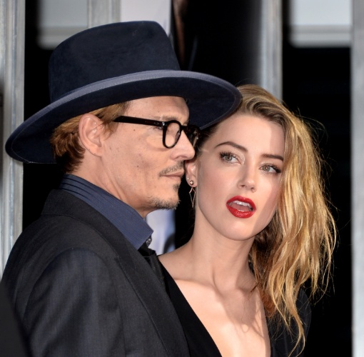 12.fev.2014 - Johnny Depp e Amber Heard posam abraçados na première de "3 Days to Kill", em Hollywood