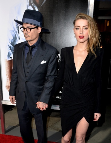 Johnny Depp beija Amber Heard trocam carinhos no tapete vermelho12.fev.2014 - Johnny Depp e Amber Heard chegam de mãos dadas à première de "3 Days to Kill", em Hollywood