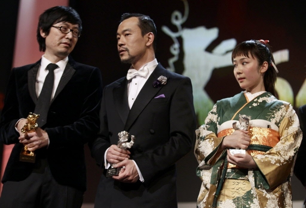 15.fev.2014 - O diretor chinês de "Black Coal, Thin Ice", Diao Yinan recebeu o urso de ouro de melhor filme. Ao lado dele, Liao Fan levou o urso de prata como melhor ator e Haru Kuroki, do filme "The Little House", também recebeu a premiação como melhor atriz - REUTERS/Tobias Schwarz